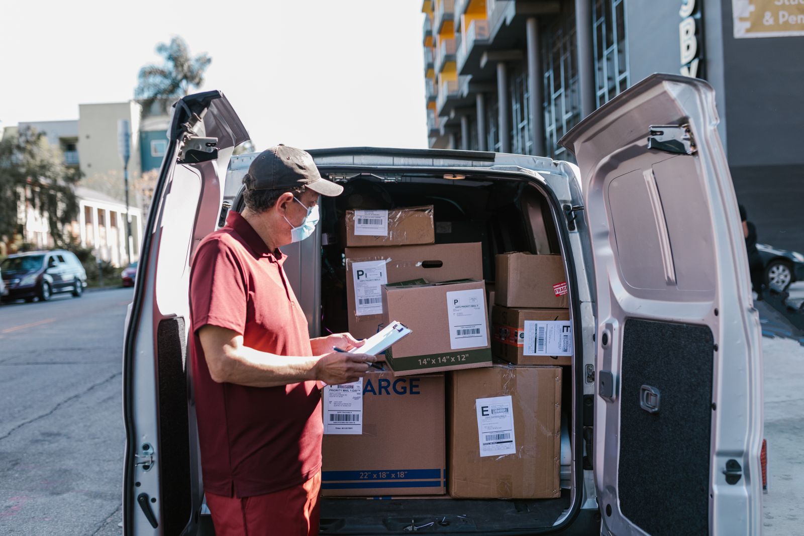 Delivery worker checking packages in a truck before departing on a multi-stop route